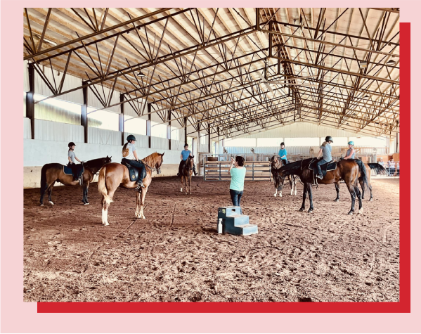 A group of people riding horses in an arena.